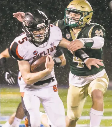  ?? John Vanacore / For Hearst Connecticu­t Media ?? Shelton’s Jack Carr battles to break free from the grasp of Notre Dame’s Zakary Hockman on Friday night in West Haven. Carr rushed for 135 yards and three touchdowns in the Gaels’ win.