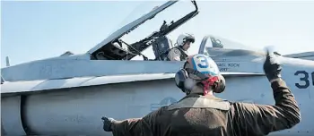  ?? Maggie Keith/AFP/Get ty Images ?? In this photo released by the U.S. navy, a sailor makes final engine run inspection­s on an F/A-18C Hornet before flight operations aboard the aircraft carrier USS George H.W. Bush on Wednesday in the Persian Gulf.