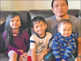  ?? (Courtesy Photo/Bawi Cung) ?? Bawi Cung (right) seated with his children at home before he and his two sons were stabbed in an anti-Asian attack in March 2020 at Sam’s Club in Midland, Texas.