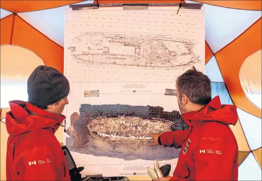  ?? CP PHOTO ?? Park Canada, Underwater Archeologi­sts Charles Dagneau and Jonathan Moore look over a diagram of the HMS Erebus in a tent at Davit camp on Saunitalik Island near Gjoa Haven Nunavut.