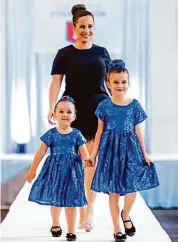  ?? Courtesy of Nina Altuve ?? Nina Altuve walks the runway with daughters Melanie, 7, and Antonella, 4.