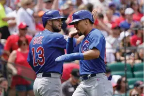  ?? The Associated Press ?? ■ Chicago Cubs’ David Bote (13) and Rafael Ortega celebrate after scoring during the fourth inning of a baseball game against the St. Louis Cardinals Sunday in St. Louis.