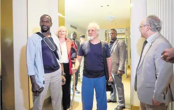  ?? JUDITH BESNARD AP ?? French journalist Olivier Dubois, left, and American aid worker Jeffery Woodke, center, arrive at an airport in Niamey, Niger, on Monday. Woodke was held by Islamic extremists in West Africa for more than six years.