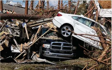  ?? JOE RAEDLE PHOTOS / GETTY IMAGES ?? A car rests on top of a truck Thursday after Hurricane Michael passed through Mexico Beach, Florida. The hurricane hit the Panhandle area with Category 4 winds causing major damage.