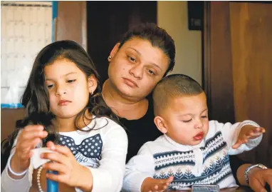  ?? RAY CHAVEZ/STAFF PHOTOS ?? Julissa Oliva, center, and her children Liz, 5, and Hector 1, live at a temporary home in Oakland with the help of Primera Iglesia Presbiteri­ana Hispana. Oliva, the children, and her partner, Jose Manuel Flores, fled to the United States from Honduras...
