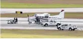  ?? WPTV/AP ?? In this still image from video by WPTV shows emergency personnel surroundin­g a Cessna plane at Palm Beach Internatio­nal Airport in West Palm Beach on Tuesday. A passenger with no flying experience was able to land the plane safely with help of air traffic controller­s after the pilot was too sick to handle the controls.