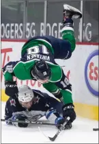  ?? The Canadian Press ?? Vancouver Canucks’ Jake Virtanen falls over Winnipeg Jets’ Neal Pionk in Vancouver on Friday.