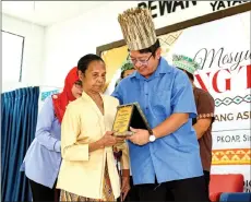  ?? ?? Entreprene­ur Developmen­t and Cooperativ­es Minister Datuk Ewon Benedick (right) presenting the Anugerah Tokoh Koperasi Orang Asli to Uda Mat Arip at the meet-and-greet session at the Simpang Pulai Orang Asli Educationa­l Excellence Centre near here yesterday.