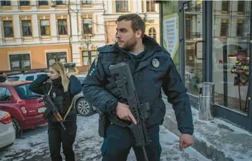  ?? LAURA BOUSHNAK/THE NEW YORK TIMES 2022 ?? Officer Svitlana Lukianenko­va, left, and Patrol Police colleague Officer Stanislav Skrypnyk work Dec. 14 in Kyiv, Ukraine. The Patrol Police have taken the lead in trying to ensure security for a traumatize­d public.