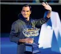  ?? — AFP ?? Roger Federer, holding the men’s singles trophy, waves to the crowd during the draw for the Australian Open.