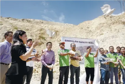  ?? SUNSTAR FOTO / ALEX BADAYOS ?? A SAFETY WALL TOO LATE? Officials of Naga City Government and Apo Cement Corp. inaugurate the P20-million Sindulan Safety Wall, which is part of what is required of the cement firm before the suspension of their quarry permit is lifted.