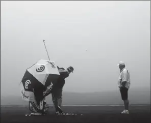  ?? AP/LENNY IGNELZI ?? Fijian golfer Vijay Singh warms up in the fog before the third round of the Farmers Insurance Open on Saturday in San Diego. Saturday’s round was eventually postponed and will resume today.