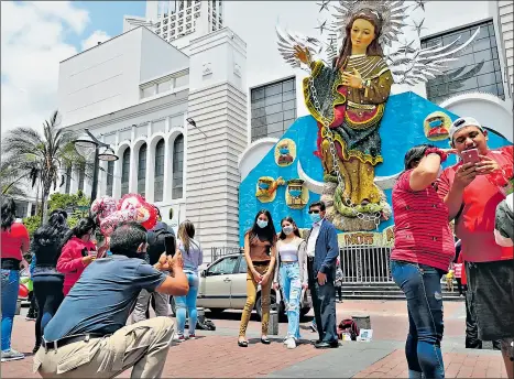  ?? Fabián maisanche / el comercio ?? • Turistas se tomaron fotos al pie de la alegoría por la edición 70 de la Fiesta de la Fruta y de las Flores en Ambato.