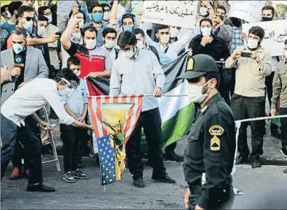  ?? EBRAHIM NOROOZI / AP ?? Estudiants iranians cremant ahir una bandera dels Estats Units davant l’embaixada dels Emirats a Teheran