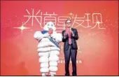  ?? PROVIDED TO CHINA DAILY ?? President of Michelin China Bruno de Feraudy and a mascot unveil the latest Shanghai Michelin Guide.
