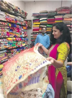  ??  ?? There’s a wealth of choices when you go sari shopping in New Delhi.