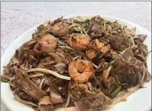  ?? LIGAYA FIGUERAS / LIGAYA.FIGUERAS@AJC.COM ?? The chow kway teow is a filling, flavorful and affordable plate of flat rice noodles studded with shrimp, squid, eggs and bean sprouts.