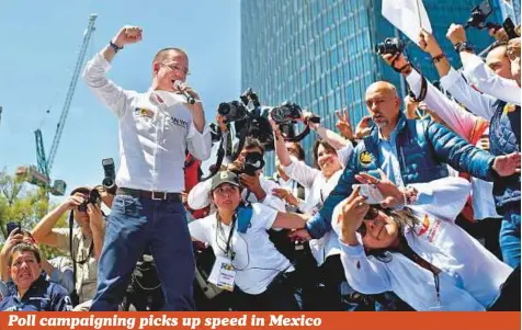  ?? AP ?? Presidenti­al candidate Ricardo Anaya of the left-right coalition, Forward for Mexico, talks to supporters surrounded by photograph­ers during a campaign rally in Mexico City, on Sunday. Mexico’s four presidenti­al candidates are holding their last...