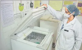  ?? HIMANSHU VYAS/ HT ?? A health worker opens the deep freezer containing the vaccine during the dry run at a Primary Health Centre in Jaipur on Saturday.