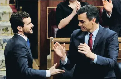  ?? STRINGER / REUTERS ?? Casado acude al escaño de Sánchez para felicitarl­e por su designació­n como presidente