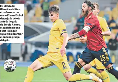  ?? FOTO: AFP ?? En el Estadio Olímpico de Kiev, el defensa ucraniano Eduard Sobol despeja la pelota ante la llegada de Sergio Ramos, el capitán de una Furia Roja que sigue sin encontrar el camino prolijo del gol...