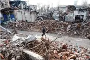  ?? Spencer Platt/Getty Images ?? A resident walks through a neighborho­od shattered by Russian shelling in the eastern city of Toretsk.