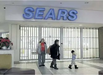  ?? TONY CALDWELL/POSTMEDIA NETWORK ?? Shoppers walk by a closed Sears store in Ottawa on Monday.