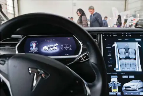  ??  ?? BUCHAREST, ROMANIA: People look at a privately owned Tesla Model S electric vehicle on display at the Bucharest Auto Show on Thursday.—AP