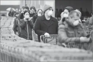  ?? Canadian Press photo ?? People wait in line to enter a Costco store in Toronto in this April file photo.