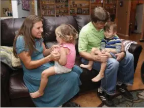  ?? RICK SCUTERI — THE ASSOCIATED PRESS ?? In this Wednesday photo, from left, Julie Armstrong, left, Amelia Anderson, Nathan Anderson and Dean Anderson sit on a couch at their home in Tucson, Ariz. Majoring in psychology, Anderson hoped to become a child psychologi­st. But after suffering a...