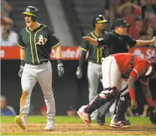  ?? Mark J. Terrill / Associated Press ?? Mark Canha exults after stealing home on the front end of a double steal in the sixth inning at Angel Stadium in Anaheim.