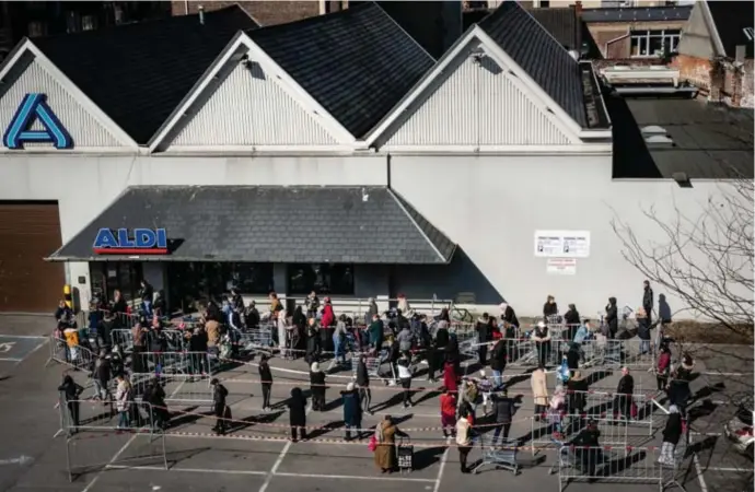  ?? © Kristof Vadino ?? Klanten schuiven aan om te winkelen in Schaarbeek. Gebruikers van de app die tijdens de besmetteli­jke fase in de buurt van de patiënt zijn geweest, krijgen een waarschuwi­ng.