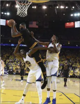  ?? KYLE TERADA —ASSOCIATED PRESS ?? Cavs center Tristan Thompson, top, jumps over Warriors forward Draymond Green (23) and Kevin Durant during Game 5 of the NBA Finals in Oakland, Calif on June 12.