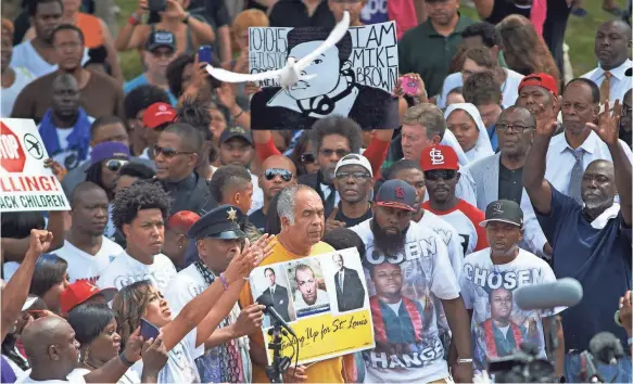  ?? MICHAEL B. THOMAS, AFP/GETTY IMAGES ?? A dove is released during a moment of silence at a memorial service for Michael Brown Jr. at the Canfield Apartments in Ferguson, Mo.