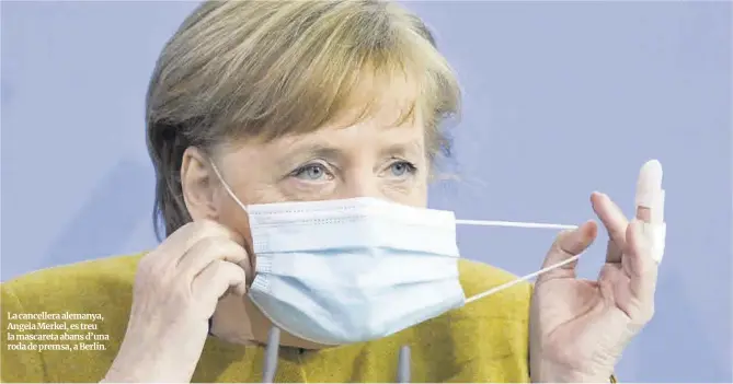  ?? Annegret Hilse / AFP ?? La cancellera alemanya, Angela Merkel, es treu la mascareta abans d’una roda de premsa, a Berlín.
