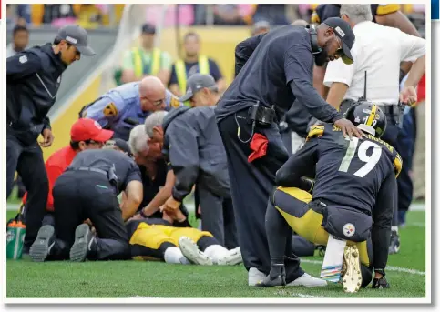  ?? — AP ?? Steelers head coach Mike Tomlin consoles wide receiver JuJu Smith-Schuster as QB Mason Rudolph is tended to after getting knocked out yesterday.