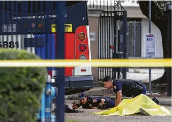  ?? Godofredo A. Vasquez / Staff photograph­er ?? Metropolit­an Transit Authority police officers investigat­e the scene where a woman was fatally struck by a bus on Wednesday in Houston. The driver faces charges in the crash.