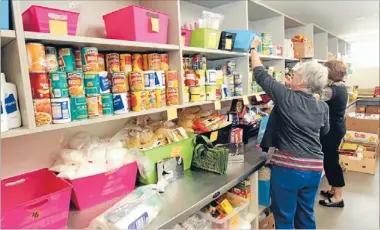  ?? Photo: DAVID HALLETT/FAIRFAX NZ ?? Vital service: Volunteers inspect the stock at the Christchur­ch City Mission’s food bank.