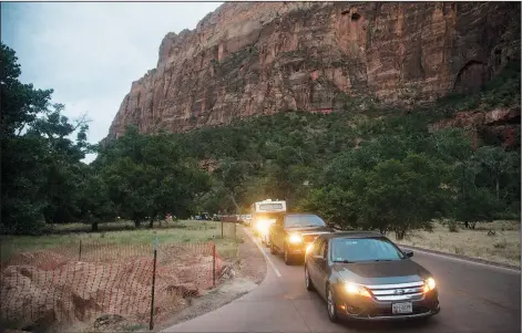  ?? (AP/The Spectrum/Chris Caldwell) ?? Hundreds of cars line up in Zion National Park every morning in hopes to get a parking spot at one of the popular trailheads in Virgin, Utah. The initial wave is limited to 400 cars, and additional vehicles wait down canyon to take their place.