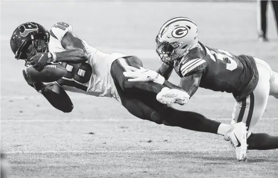  ?? Photos by Brett Coomer / Staff photograph­er ?? Texans wide receiver Chris Conley stretches to make a diving catch against Packers cornerback Josh Jackson for a first down during the second quarter Saturday.