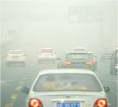  ?? WANG ZHAO / AFP / GETTY IMAGES FILES ?? Commuters in heavy pollution in Beijing. China still produces most of its electricit­y with coal-fired plants.