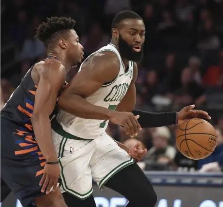  ?? AP ?? PULLING IT OUT: Jaylen Brown dribbles by New York’s Dennis Smith Jr. on Sunday afternoon.