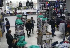  ?? ?? people shop at grand slam, a souvenir and sports apparel store, in Times square on monday in new York.