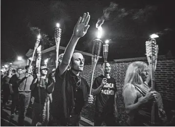  ?? EVELYN HOCKSTEIN/THE WASHINGTON POST ?? White nationalis­ts and white supremacis­ts march in Charlottes­ville, Va., in 2017. Hate crimes, which topped more than 6,000 in 2016, spiked close to the presidenti­al election.