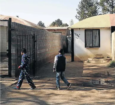  ?? /THULANI MBELE ?? Local children walk past the murder scene where intelligen­ce police officer Ntobeko Nhlanhla Langa was shot dead in White City, Soweto.