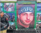  ?? AFP ?? A policewoma­n stands guard beside a carriage bearing Burhan Wani’s image on Pakistan Railways’ Azadi train.