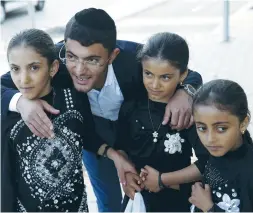  ?? (Baz Ratner/Reuters) ?? THREE YEMENITE girls who were brought to Israel by the Jewish Agency are greeted by a relative, Zion Dahari, in March 2016 at an absorption center in Beersheba.