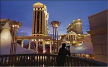  ?? JOHN LOCHER / AP 2015 ?? A man takes pictures of Caesars Palace hotel and casino, in Las Vegas. Billionair­e investor Carl Icahn plans to drive casino giant Caesars Entertainm­ent to sell itself.