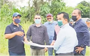  ??  ?? TAPAK PERUMAHAN: Masiung (kiri) ketika melawat tapak cadangan perumahan mampu milik di Kampung Taka, Pitas.