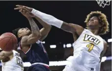  ?? KEITH SRAKOCIC/THE ASSOCIATED PRESS ?? Richmond’s Khwan Fore, left, loses the ball as VCU’s Justin Tillman defends during the Atlantic 10 tournament semifinals on Saturday.